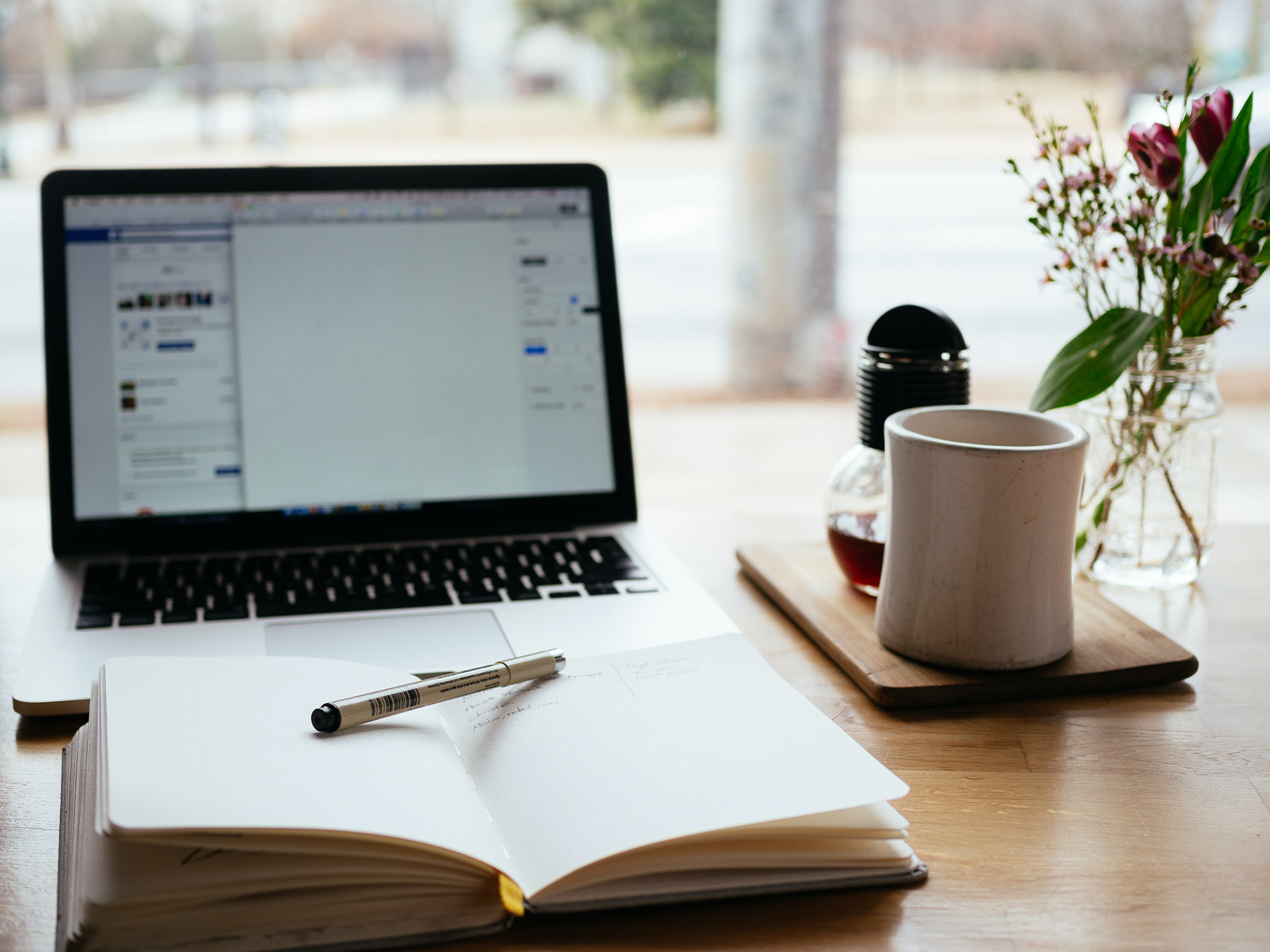 Computer, Pen, Paper and Coffee mug on table to iillustrate good WordPress blog design