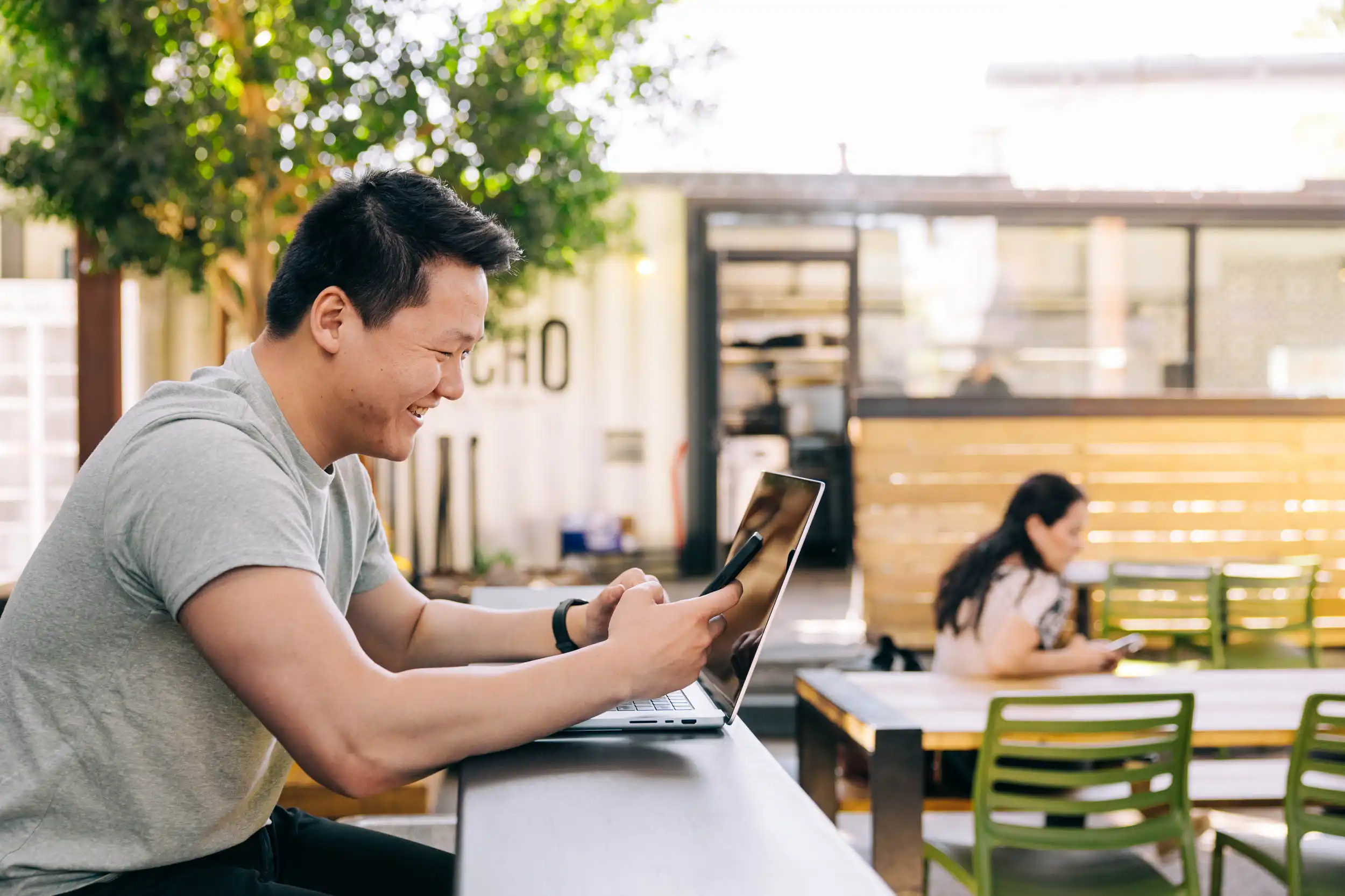 Man looking at phone and computer searching for web design trends of 2025