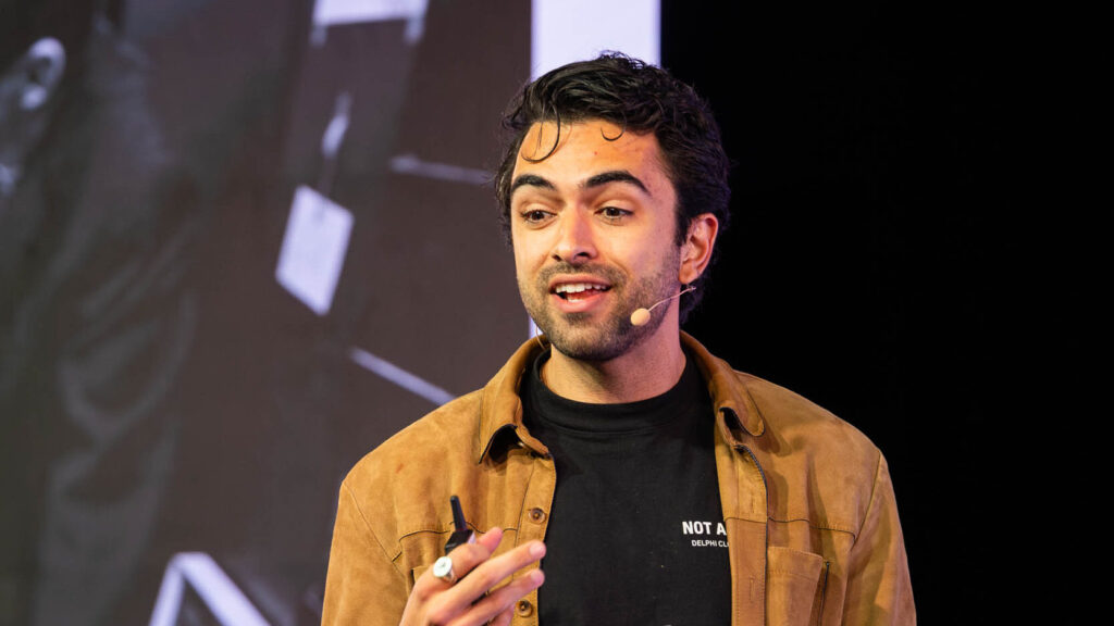 732A6439-Enhanced-NR-web - Showit man speaking into a microphone from the article about Prepare For Your First Speaking Opportunity