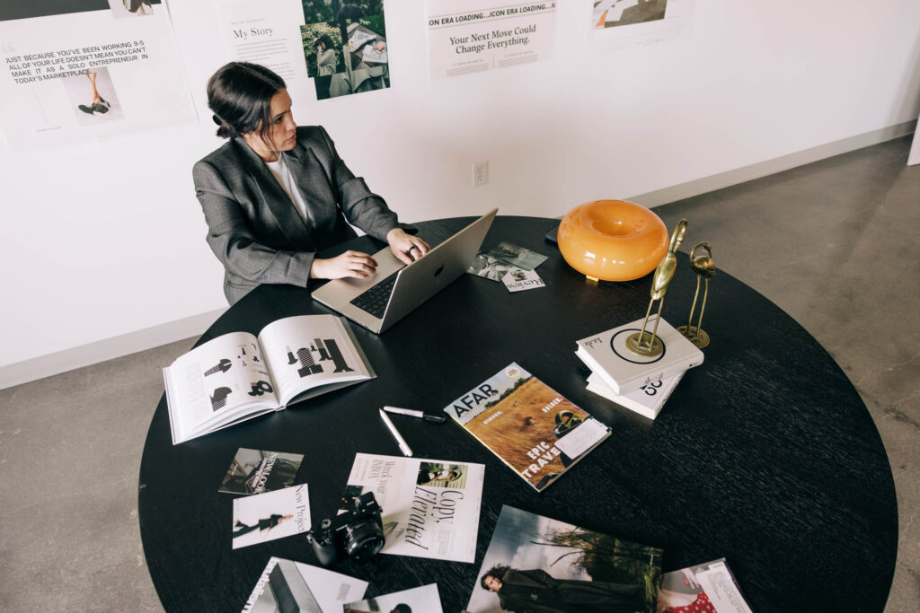 Woman working on a laptop at a table in the 2026 Marketing Playbook blog