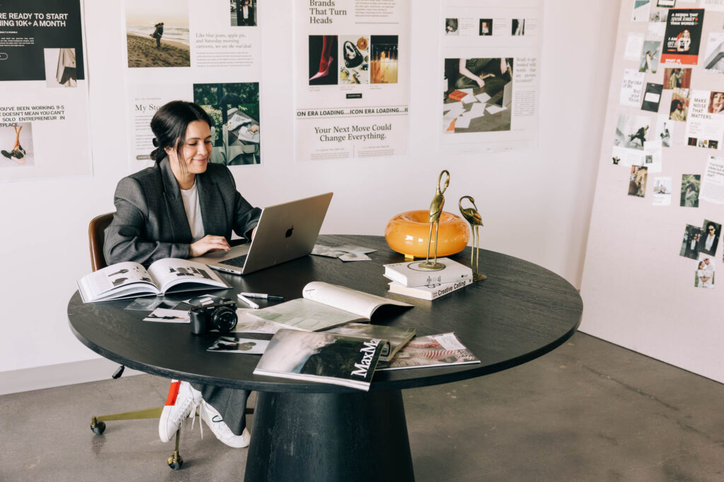 Woman blogging on her laptop at a table.