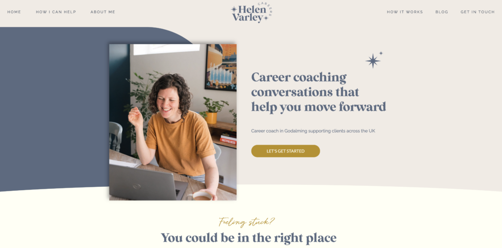 The homepage of hvcareers.co.uk featuring a warm photo of Helen Varley laughing at her desk, set against a dusty blue geometric background shape, with the headline "Career coaching conversations that help you move forward.